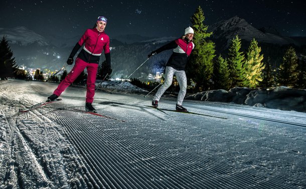 Langlaufen auf der Nachtloipe in Davos bei Flutlicht.